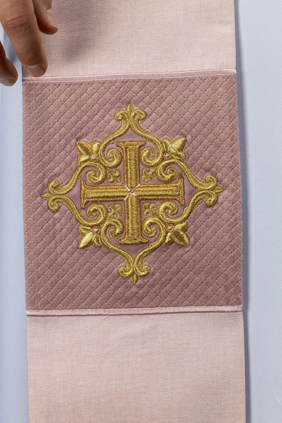 Rose stole detail with embroidered gold cross on quilted velvet