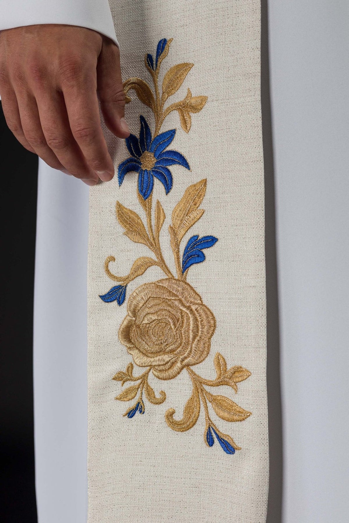 Embroidered stole close-up with gold crowned Marian symbol and large gold M