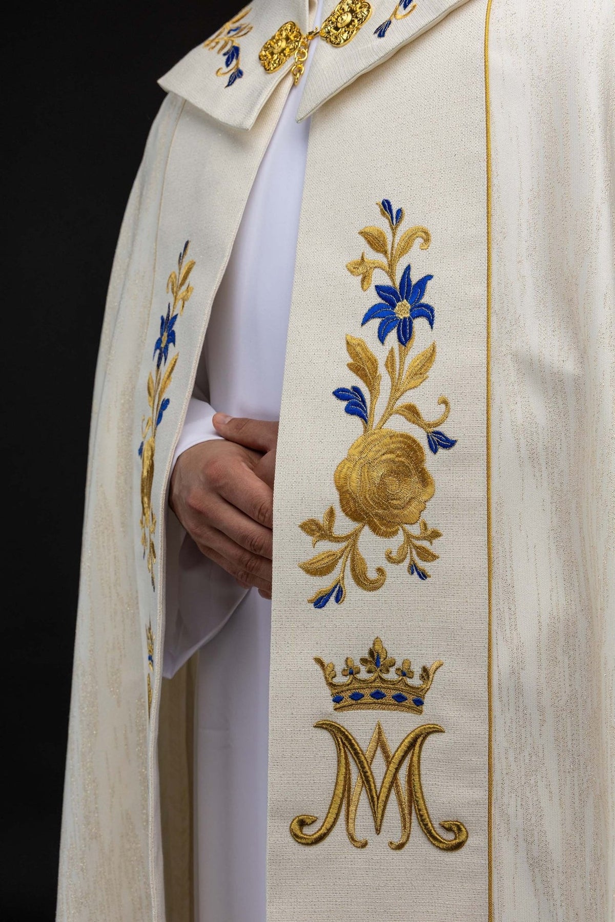 Ecru cope close-up of embroidered floral orphrey with gold Marian symbol