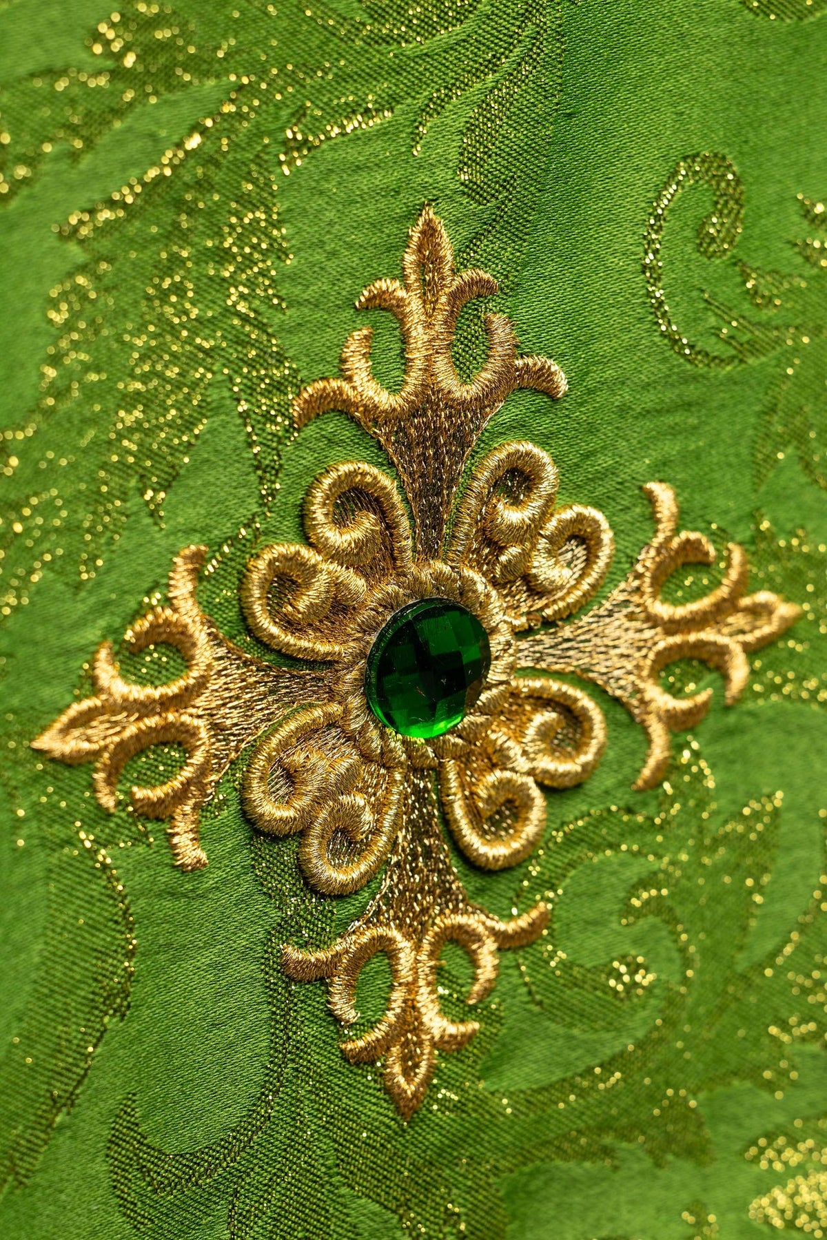 Chalice veil close-up of embroidered gold cross motif and green stone