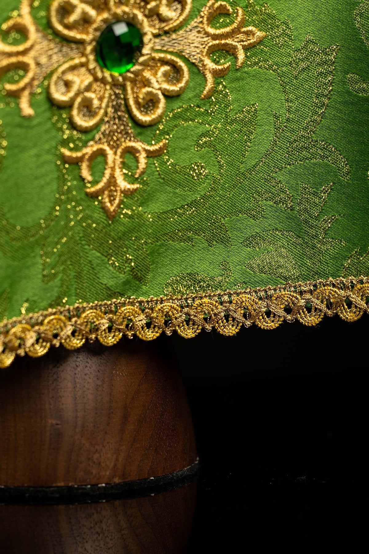 Chalice veil detail showing green stone, gold embroidery, and decorative trim