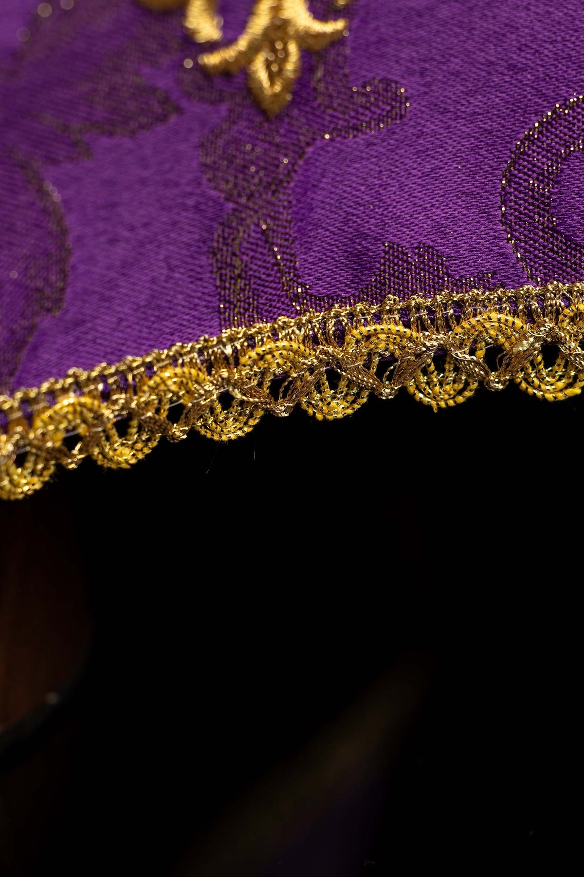 Chalice veil close-up showing purple brocade fabric and gold scalloped trim
