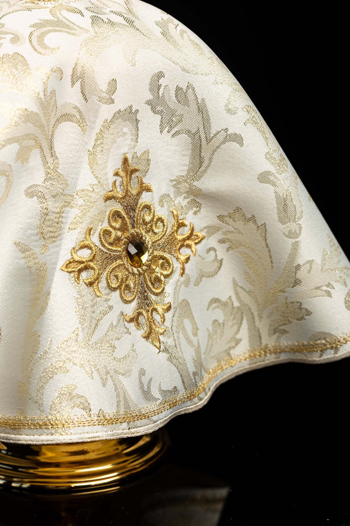 Ecru ciborium veil close-up showing embroidered cross, central stone, and gold-trimmed edge