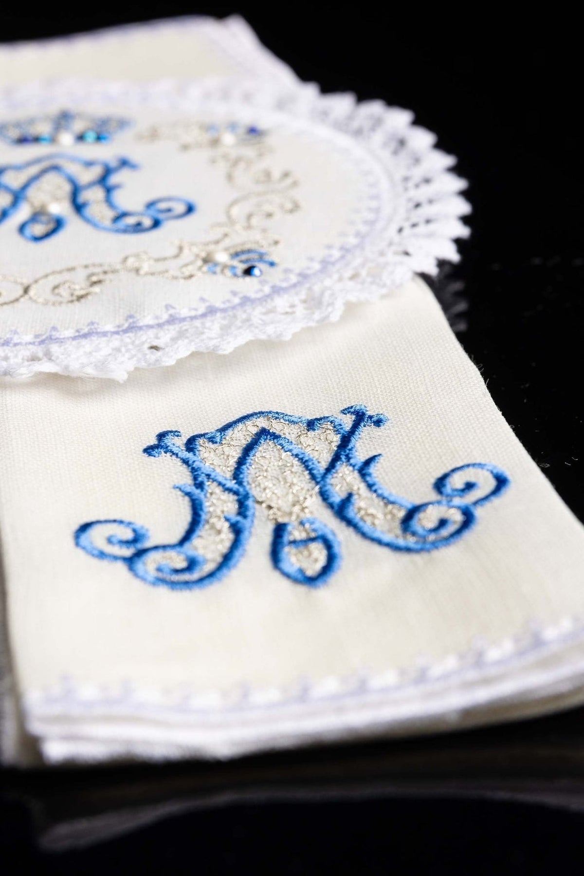 Altar linen close-up showing ornate blue and gold embroidery with lace edging