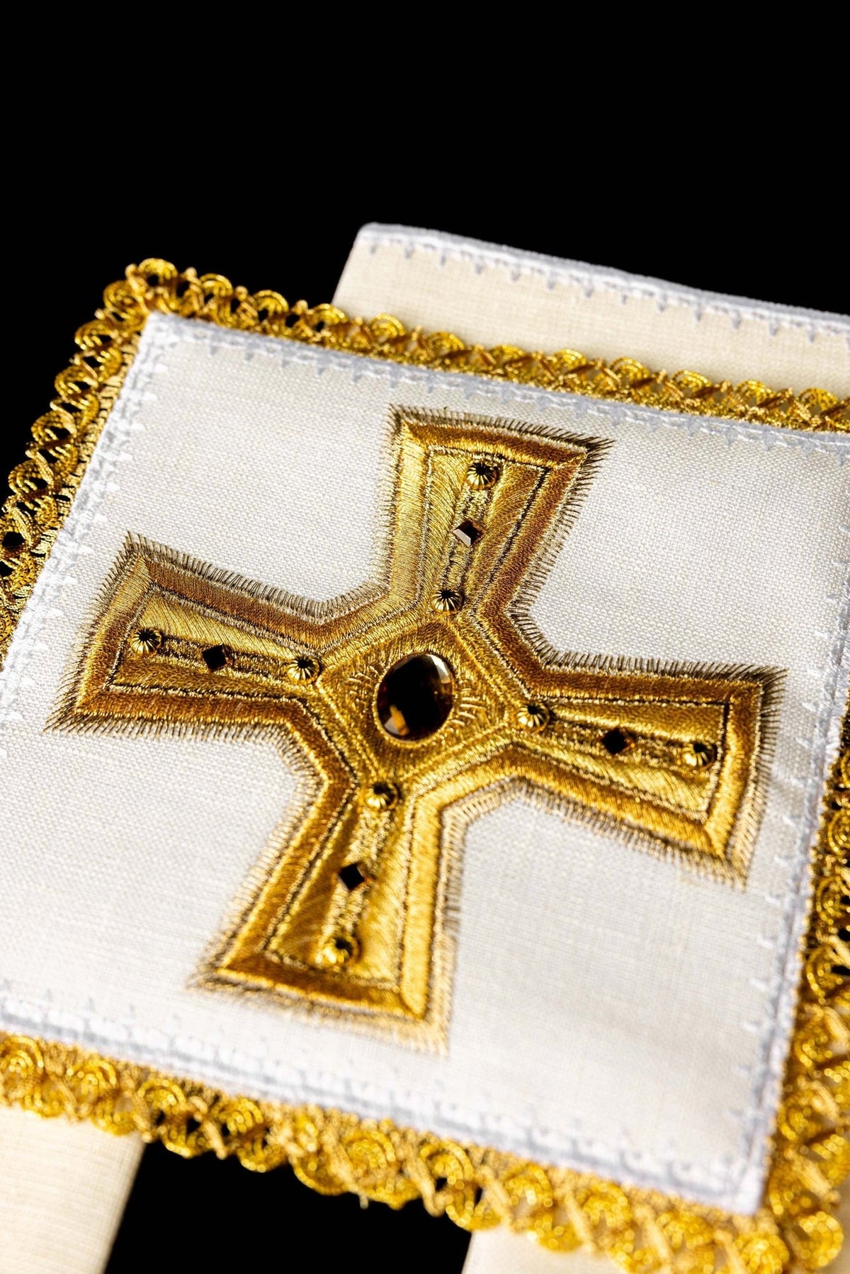 Altar linen set close-up showing gold embroidered cross with central and smaller stones