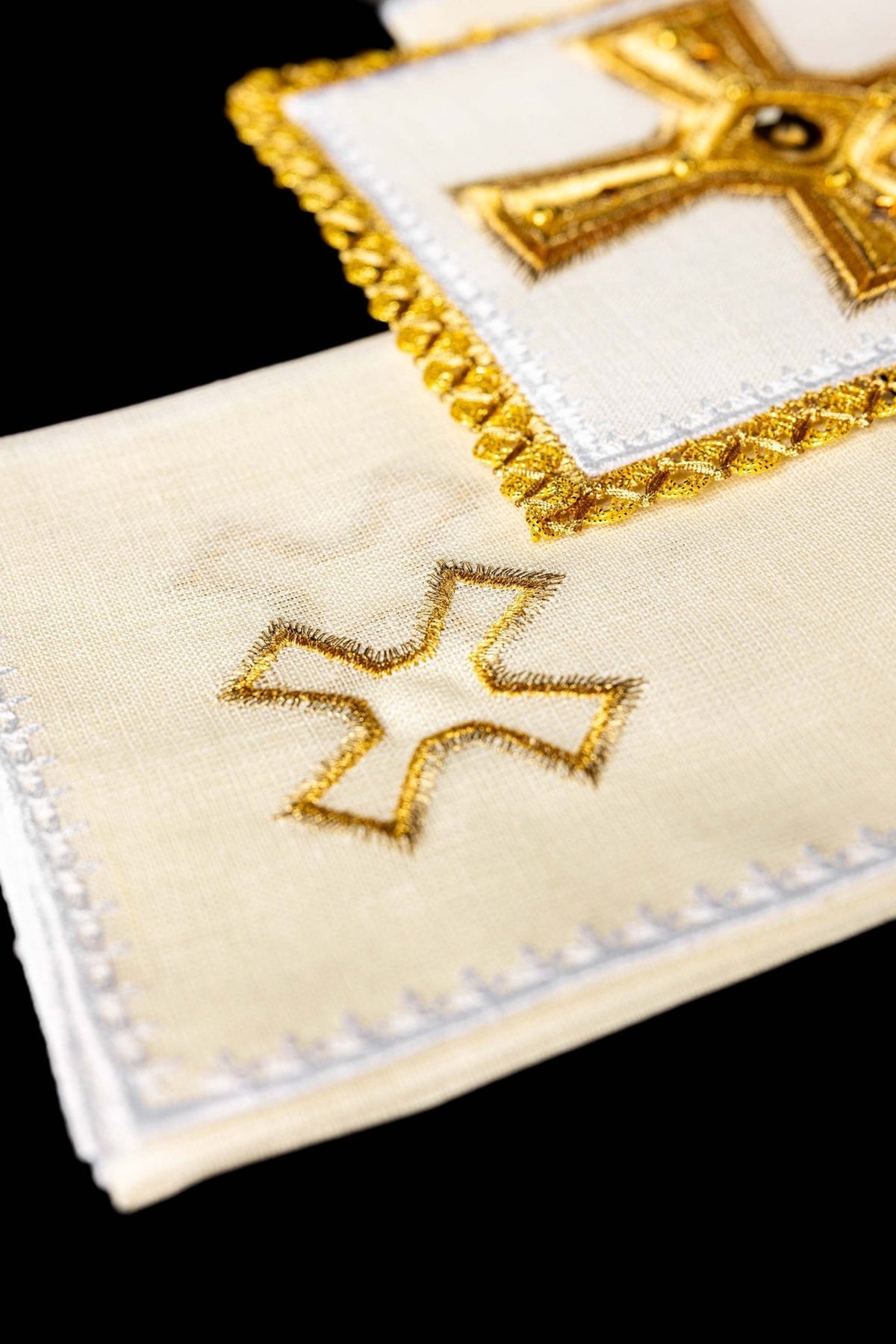 Altar linen set detail showing a white linen piece with an outlined gold cross