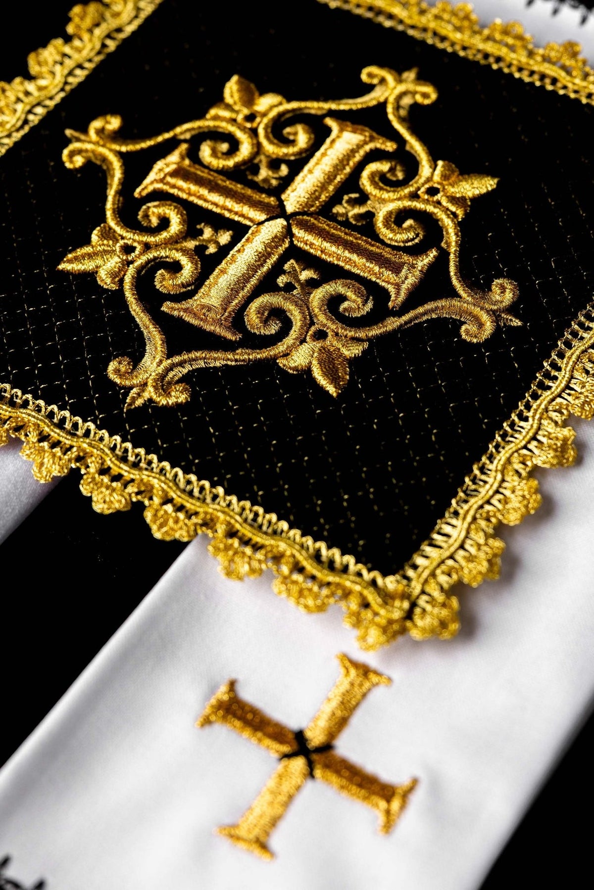 Altar linen set close-up showing gold embroidered cross and ornate gold trim on black velvet