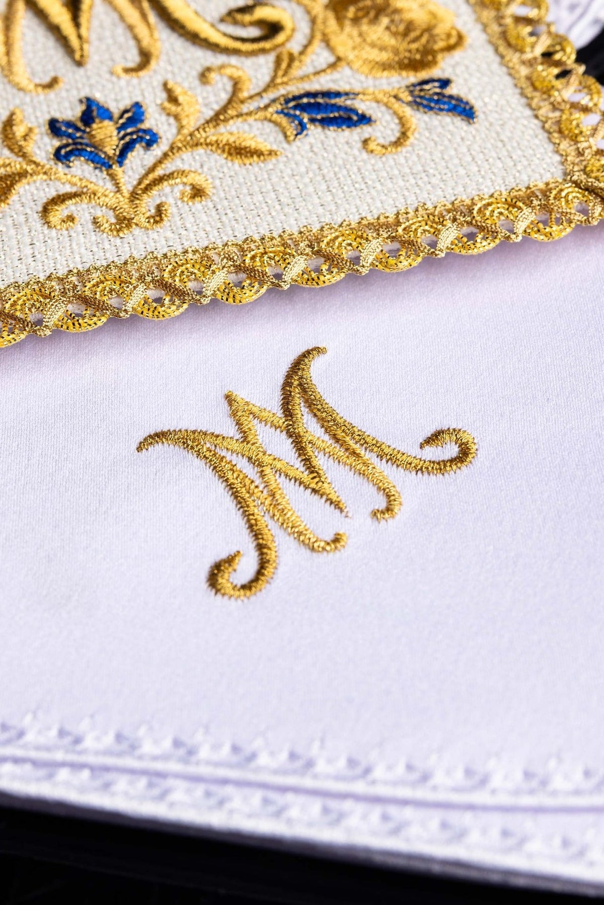 Altar linen set detail showing gold embroidered Marian monogram and trim
