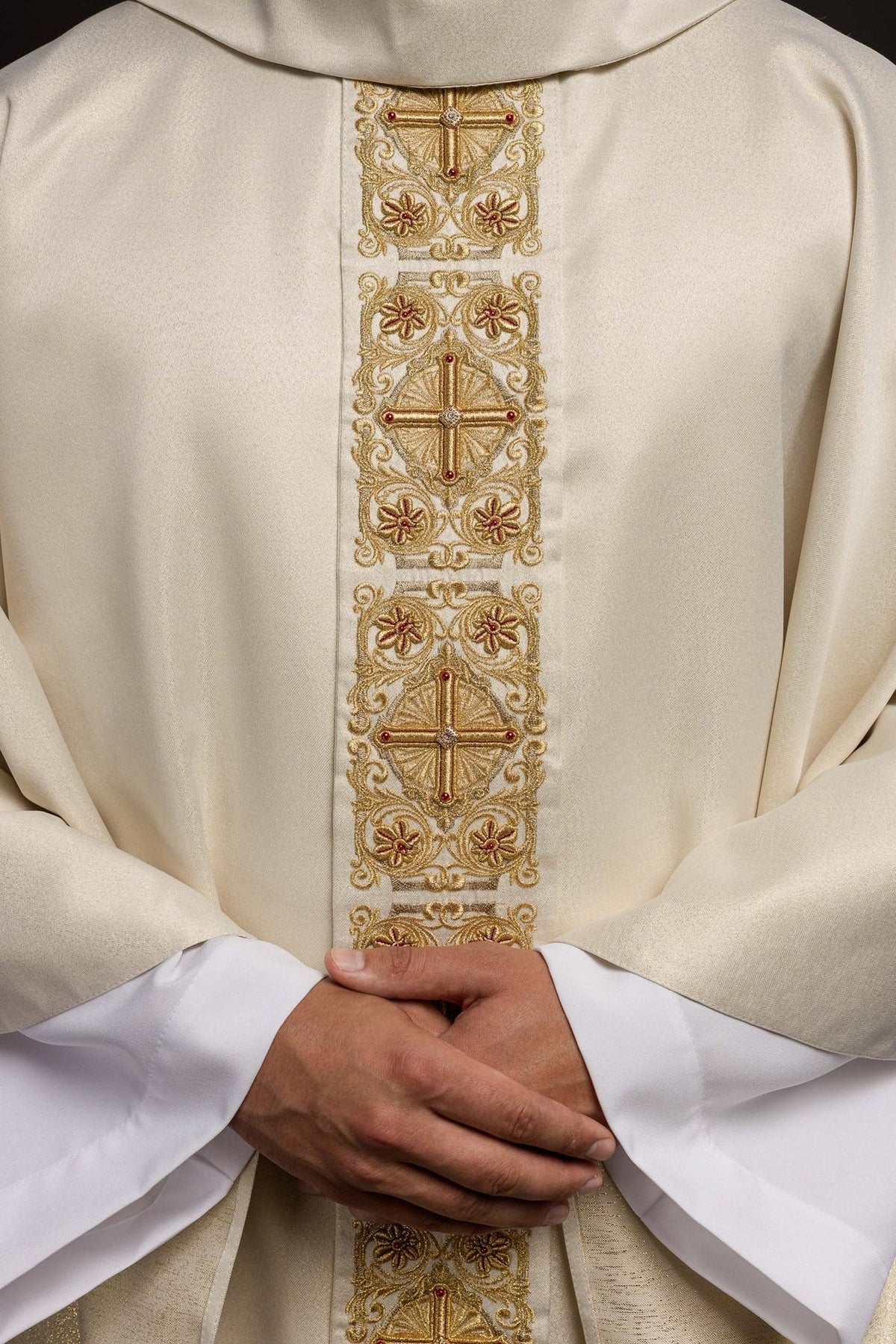Chasuble close-up showing embroidered gold orphrey with crosses, flowers and red accents