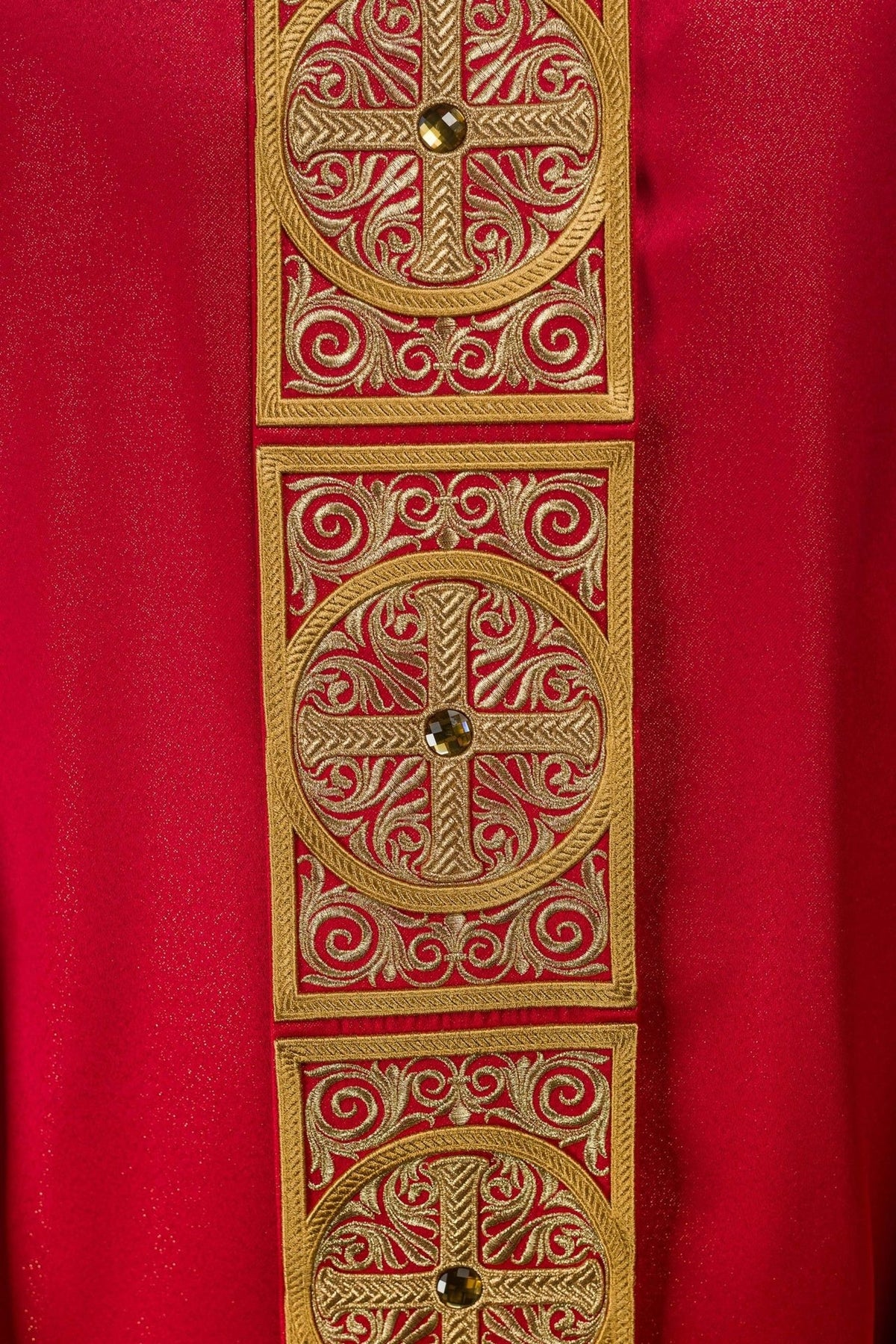 Red chasuble side detail showing embroidered orphrey and wide sleeves