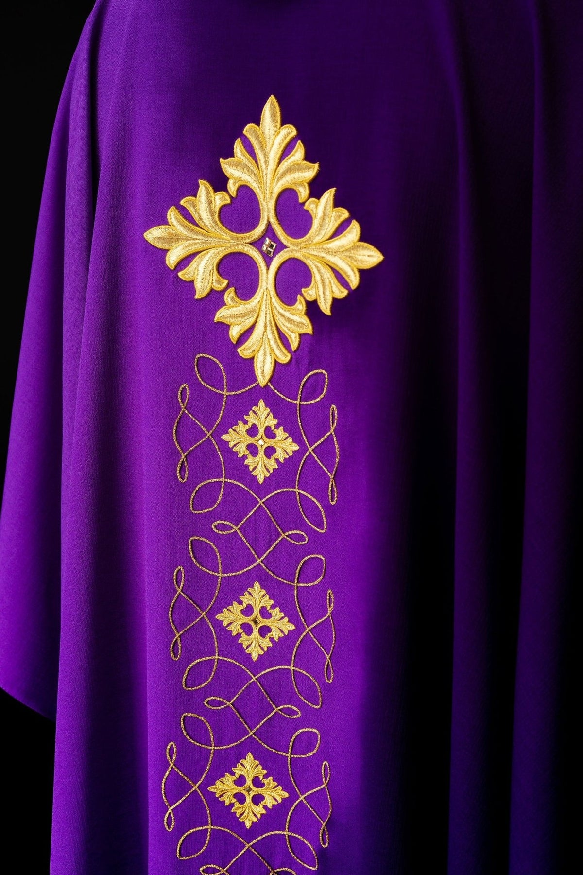Purple chasuble front detail with embroidered cross, stones and looping gold cord