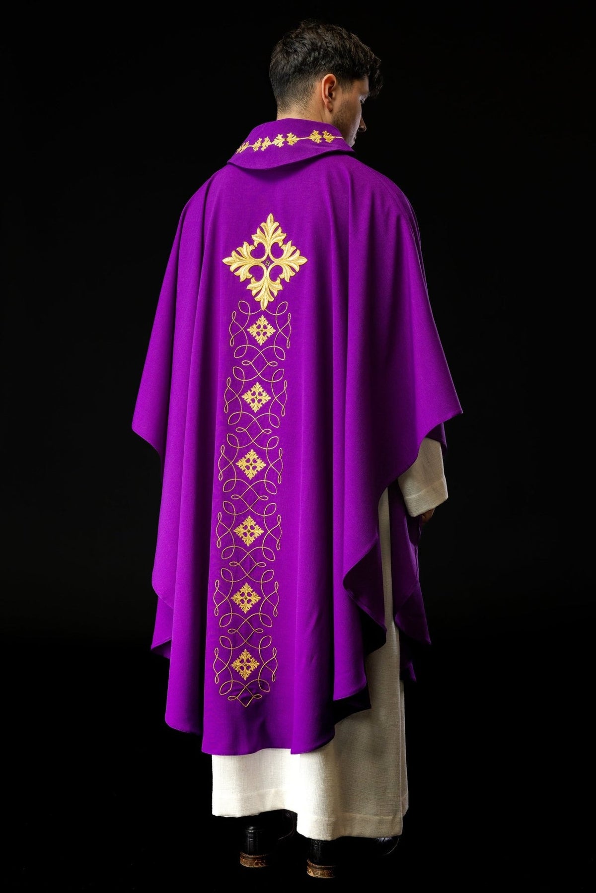 Purple chasuble worn from the back with a long gold embroidered panel