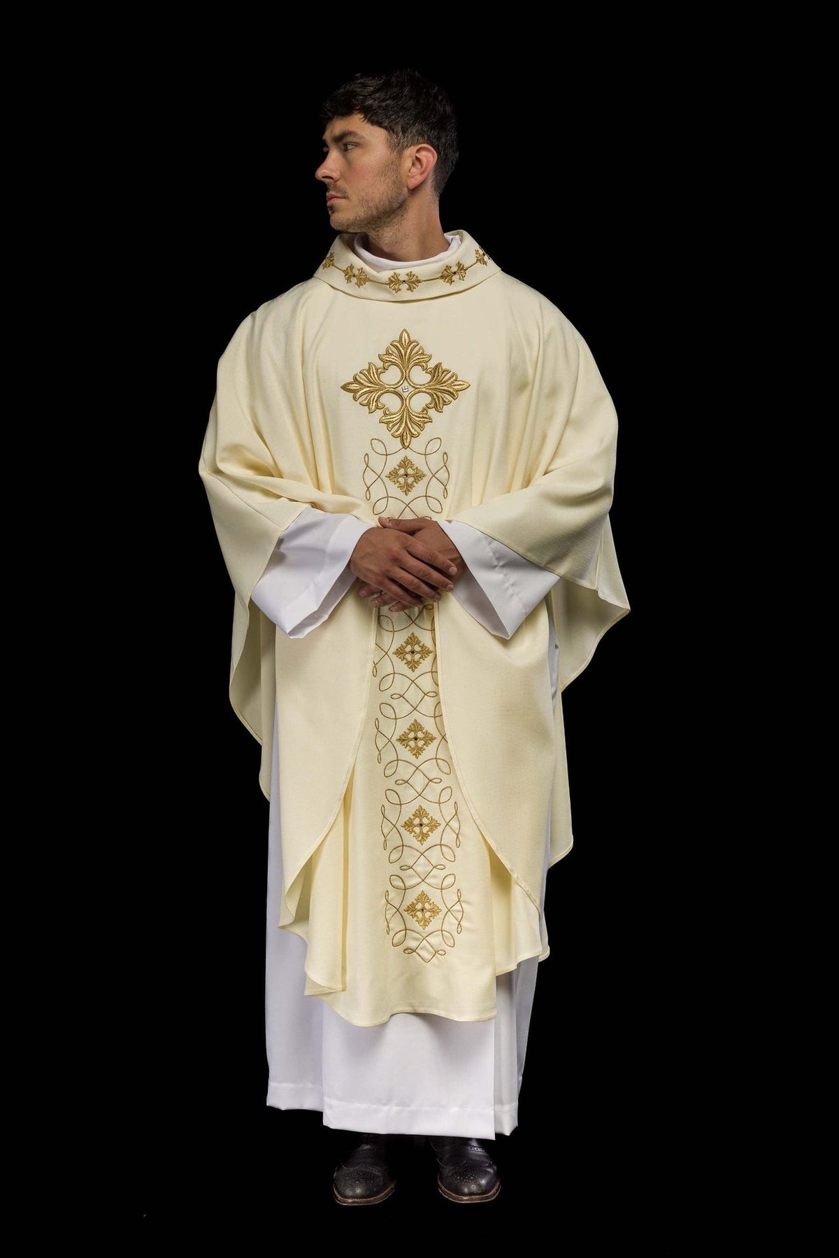 Ivory embroidered chasuble angled front view with gold cross and scrolling panel