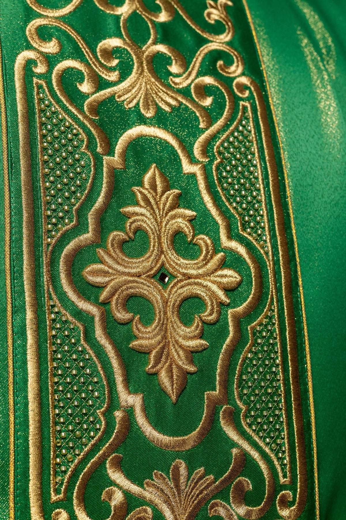 Green chasuble close-up showing ornate gold embroidery and beaded trim