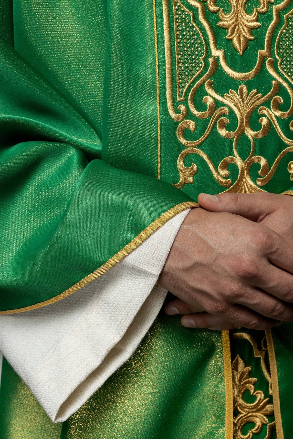 Green chasuble close-up showing shimmering fabric, gold embroidery and trim