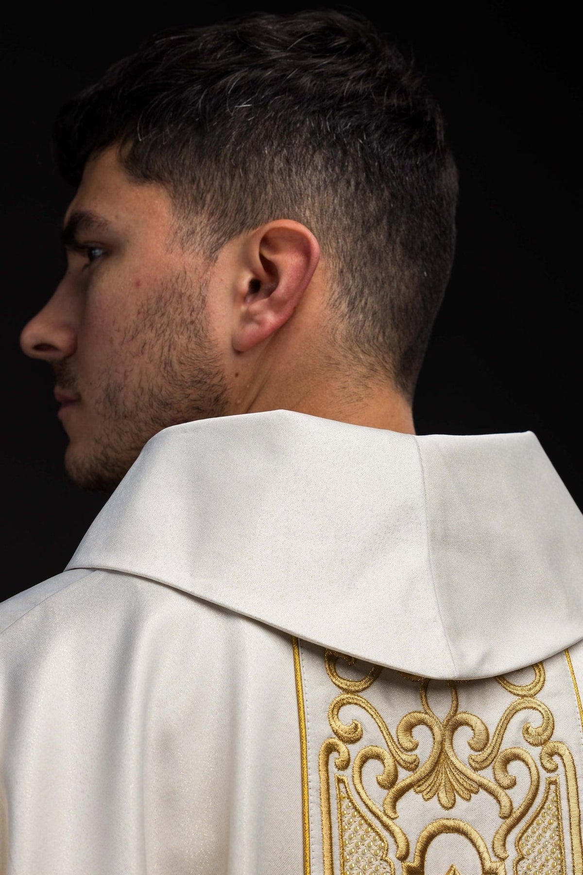 White chasuble close-up showing the gold-trimmed stand-up collar and upper orphrey embroidery