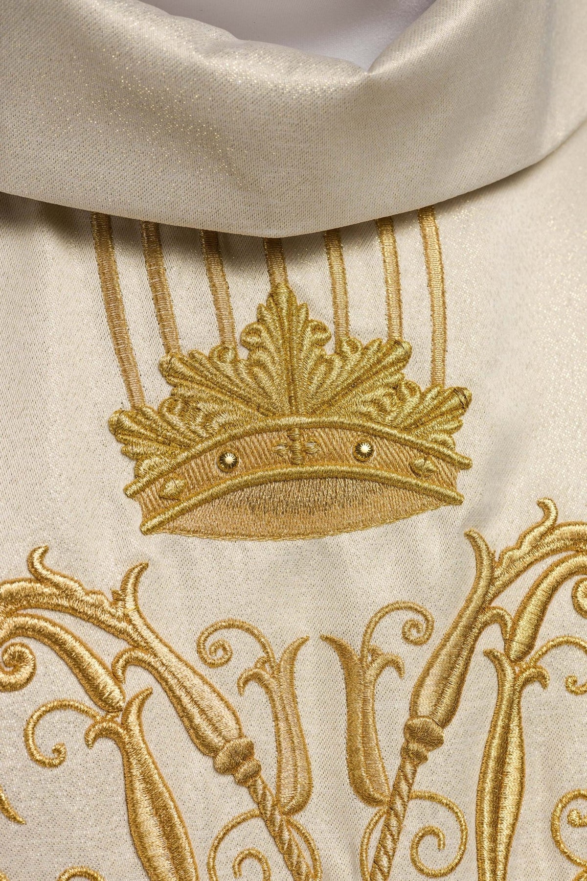Ecru chasuble detail showing gold vertical embroidery and shimmering polyester fabric