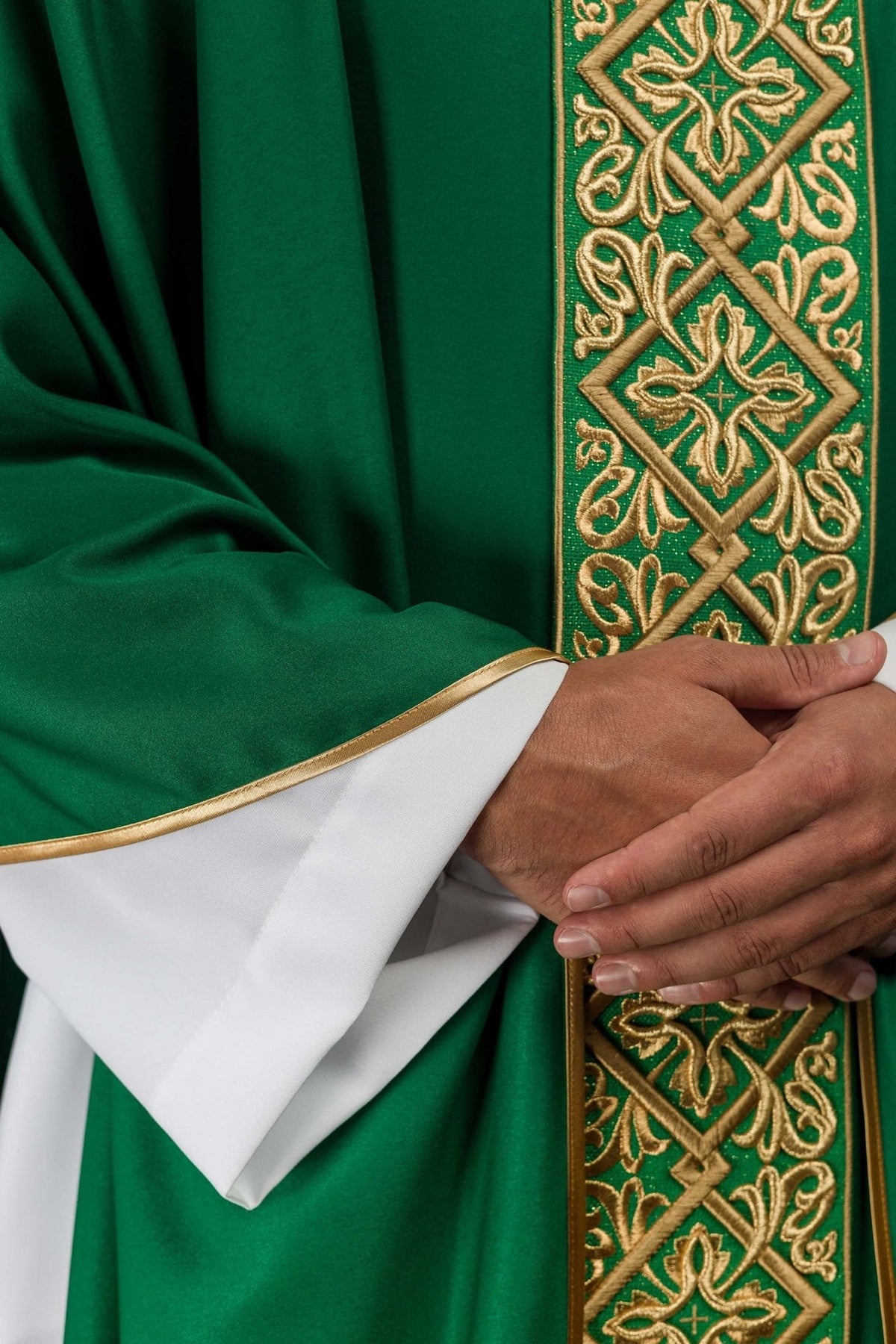 Green chasuble close-up showing gold embroidery and satin trim at the sleeve