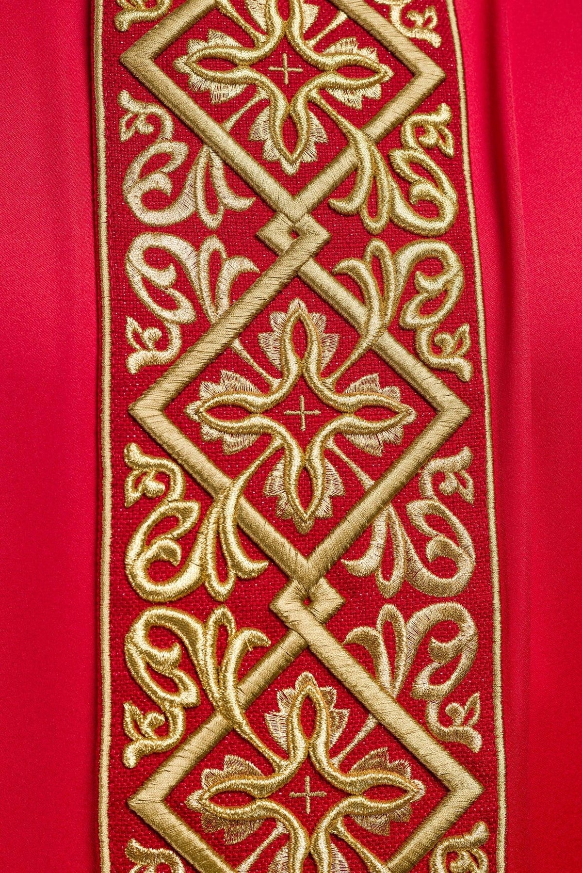 Red chasuble close-up of gold floral embroidery and crosses on the front panel