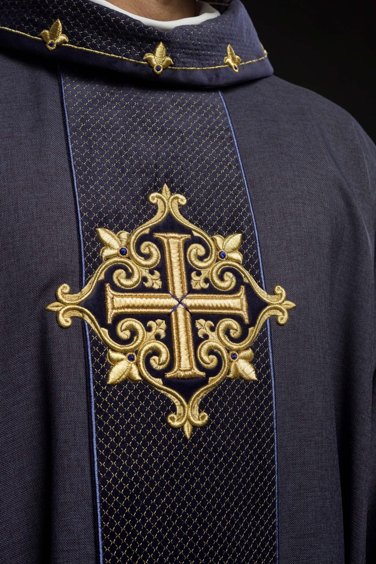 Velvet chasuble close-up showing embroidered gold cross and quilted stand-up collar