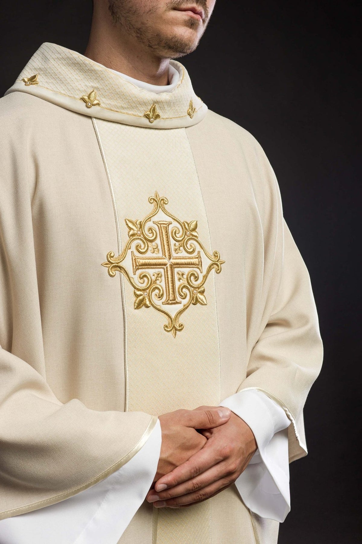 Ecru chasuble close-up showing gold cross embroidery and quilted stand-up collar