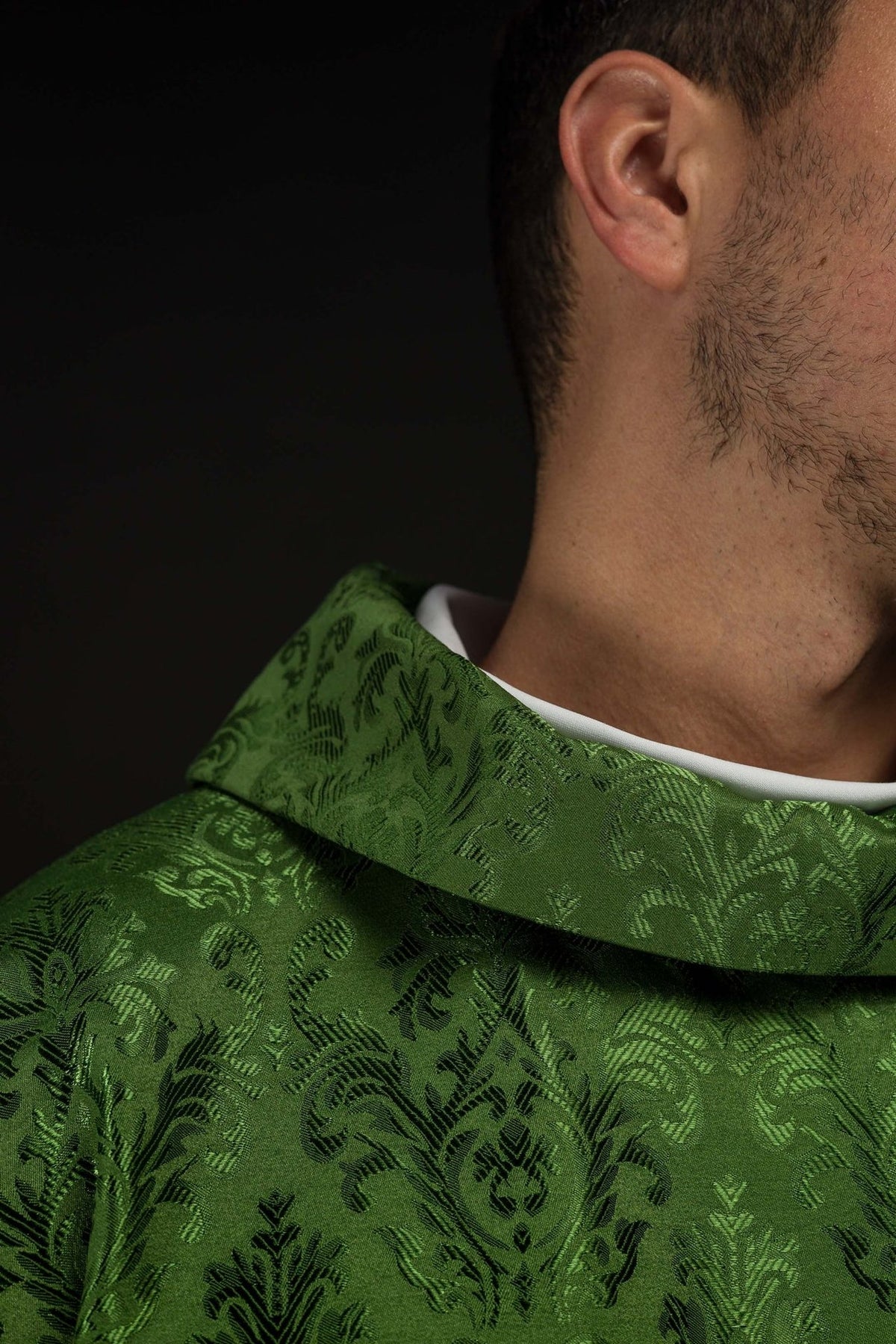 Green chasuble close-up showing stand-up collar and decorative fabric