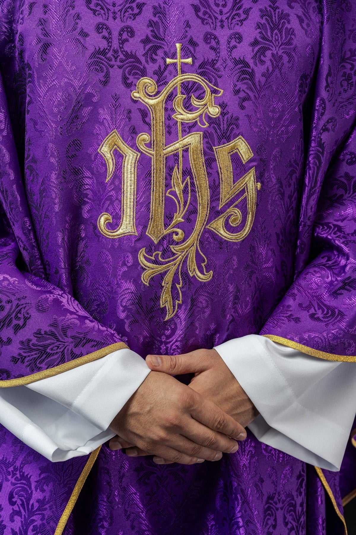Purple chasuble close-up of gold embroidered IHS motif and gold trim