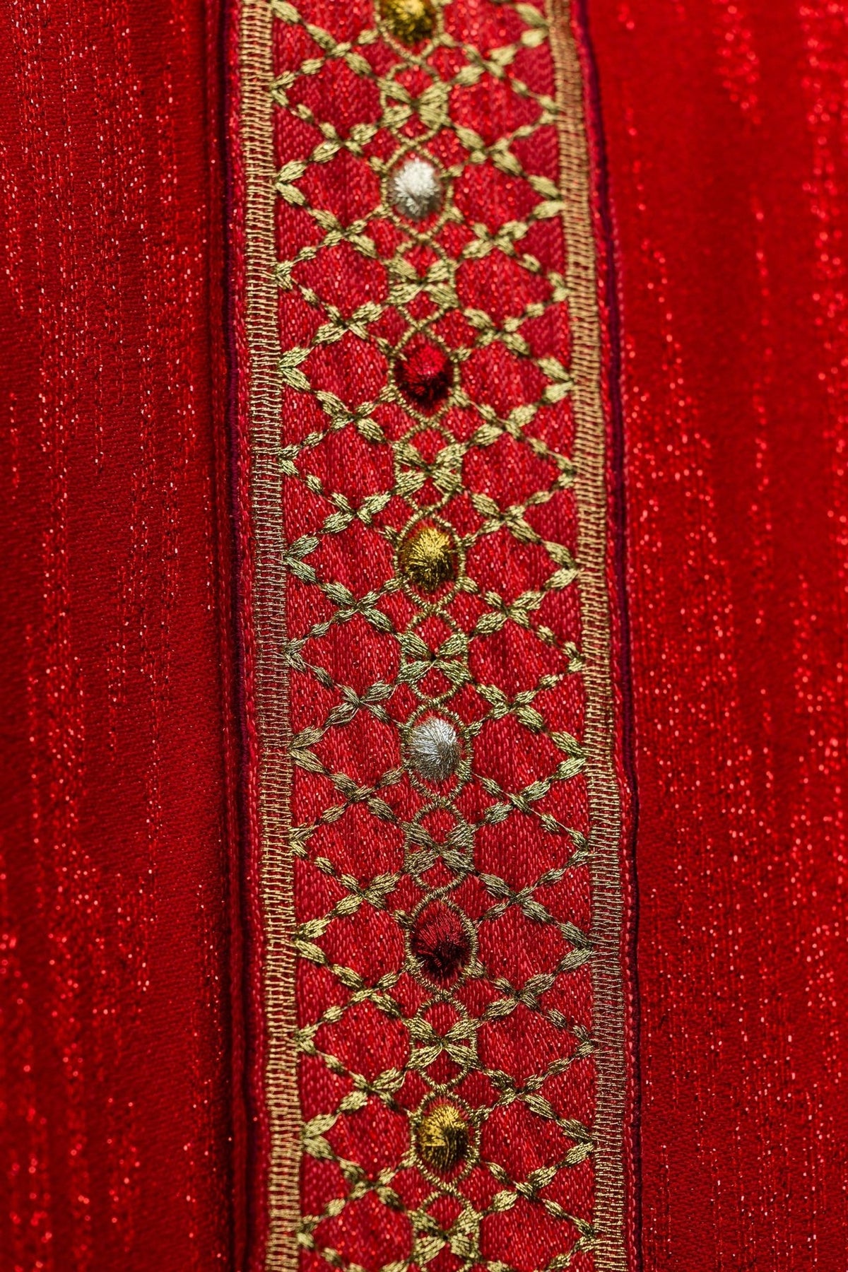 Red chasuble close-up of embroidered orphrey with gold lattice and floral motifs