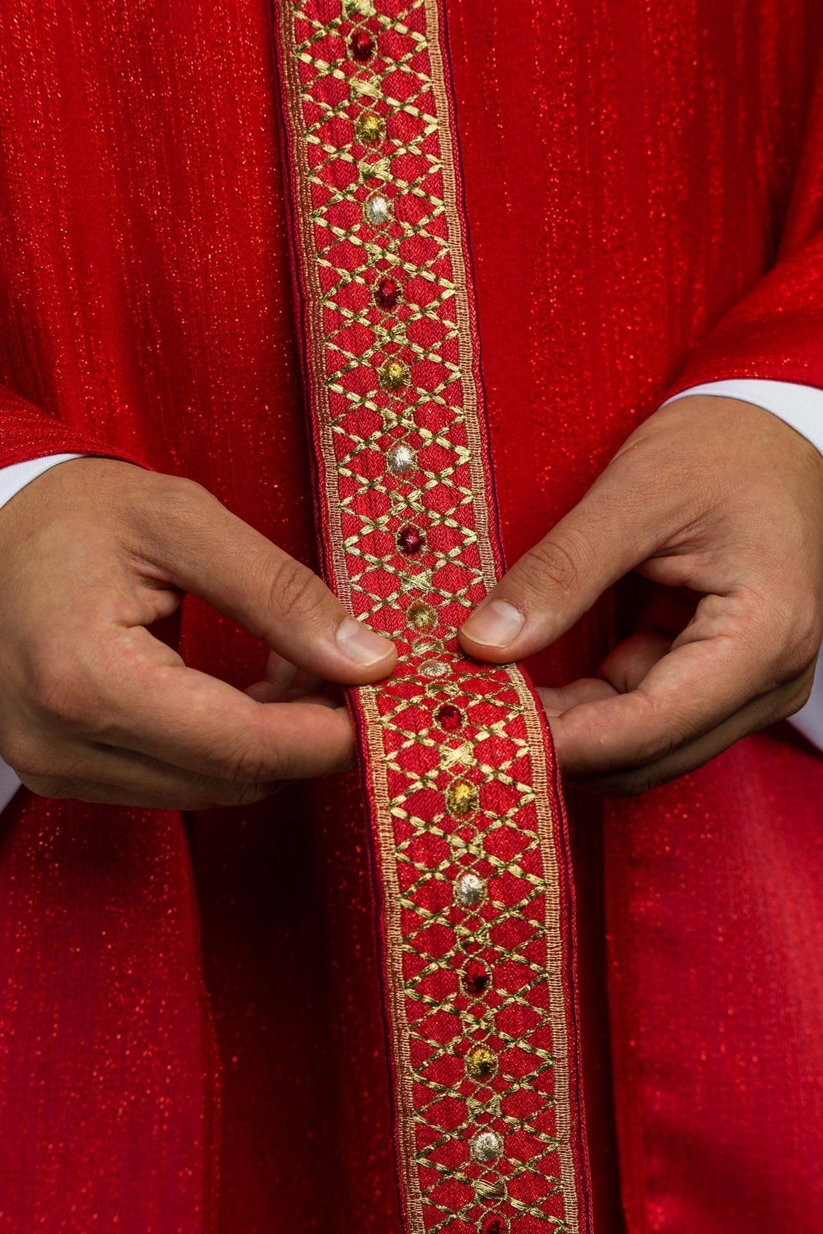 Red chasuble orphrey close-up showing gold trim and multicolour embroidery
