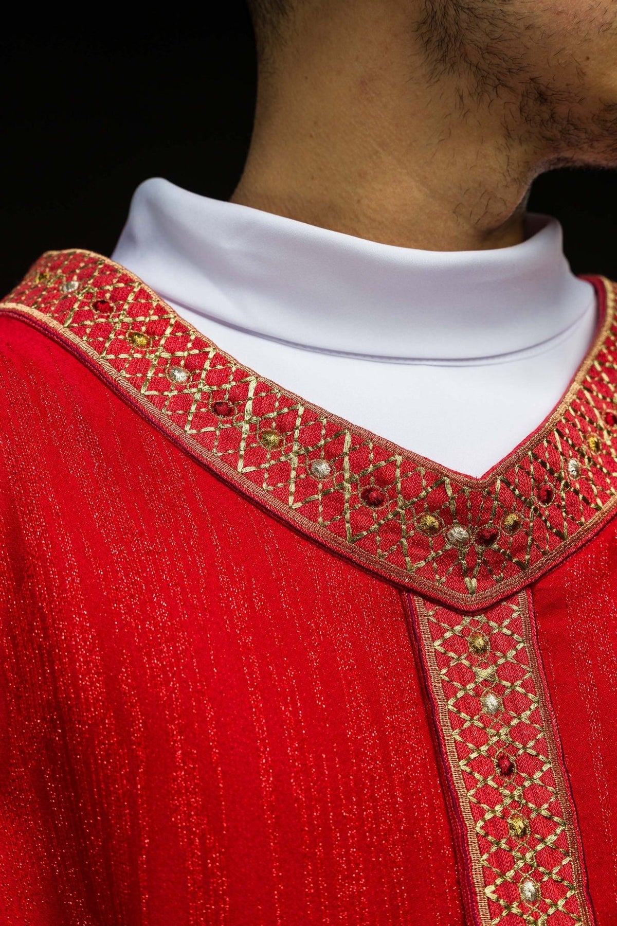 Red chasuble front detail showing embroidered orphrey and gold trim
