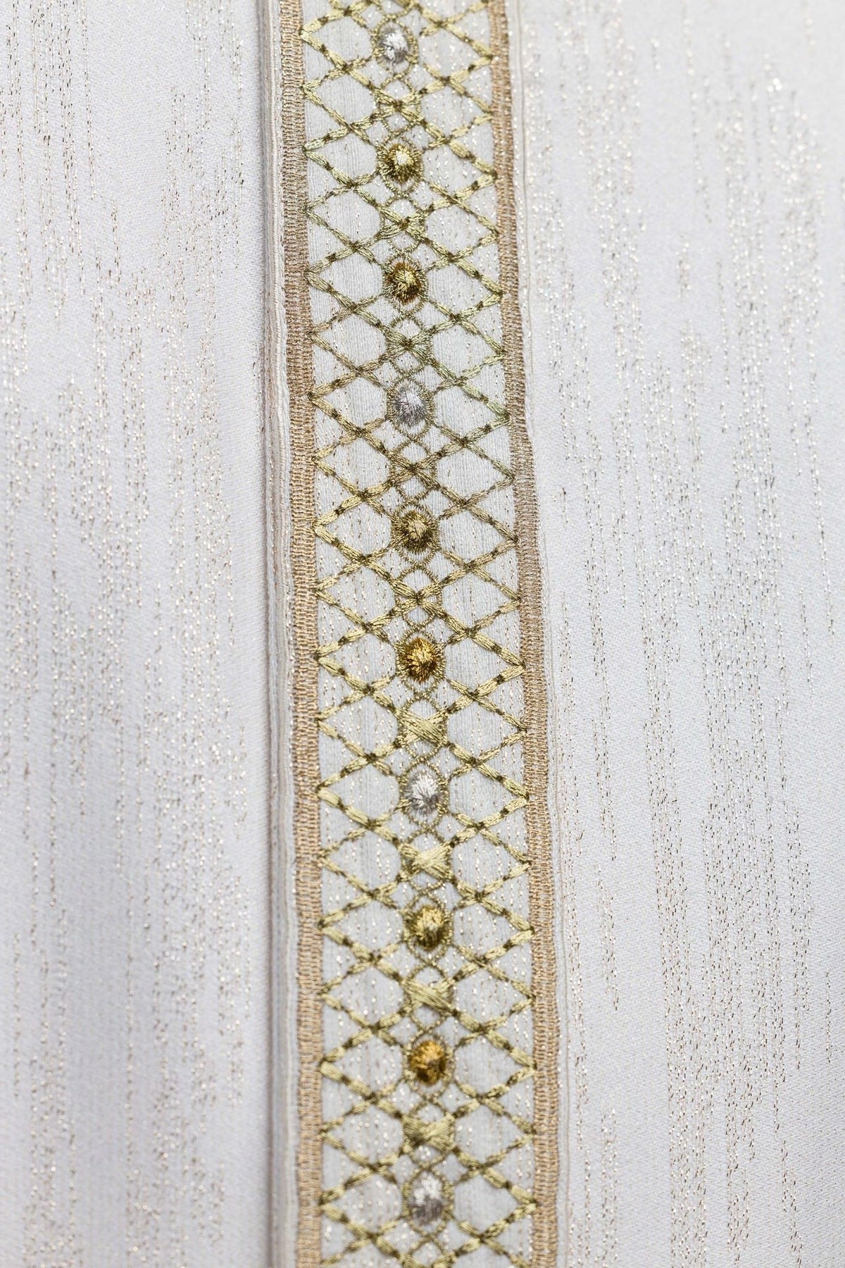 White chasuble orphrey close-up with gold lattice embroidery and floral motifs