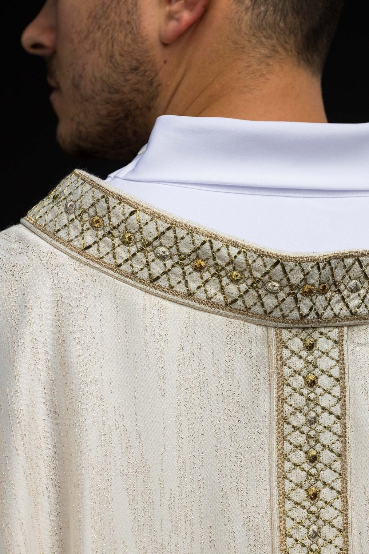 White chasuble collar close-up with gold embroidered floral lattice