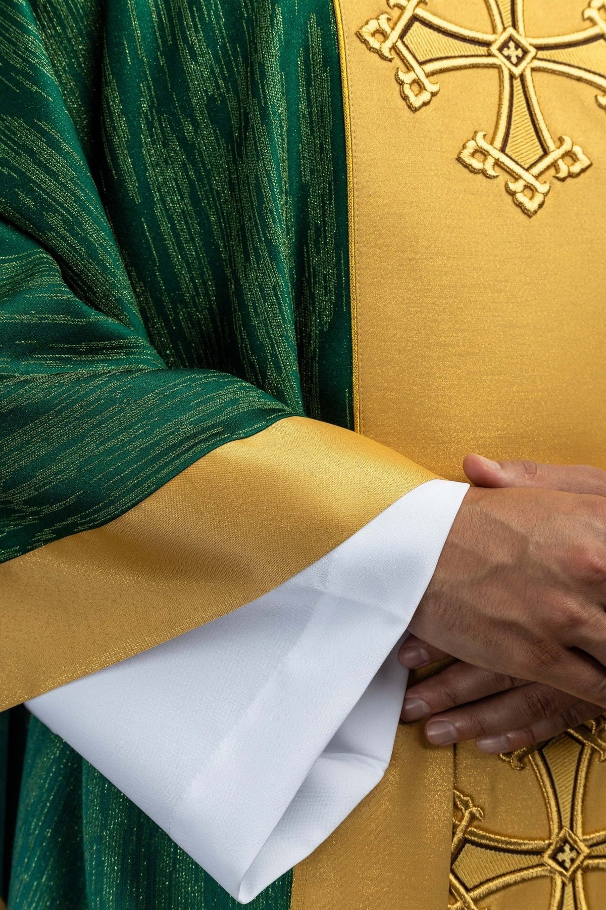 Green chasuble detail showing gold orphrey trim and green patterned fabric