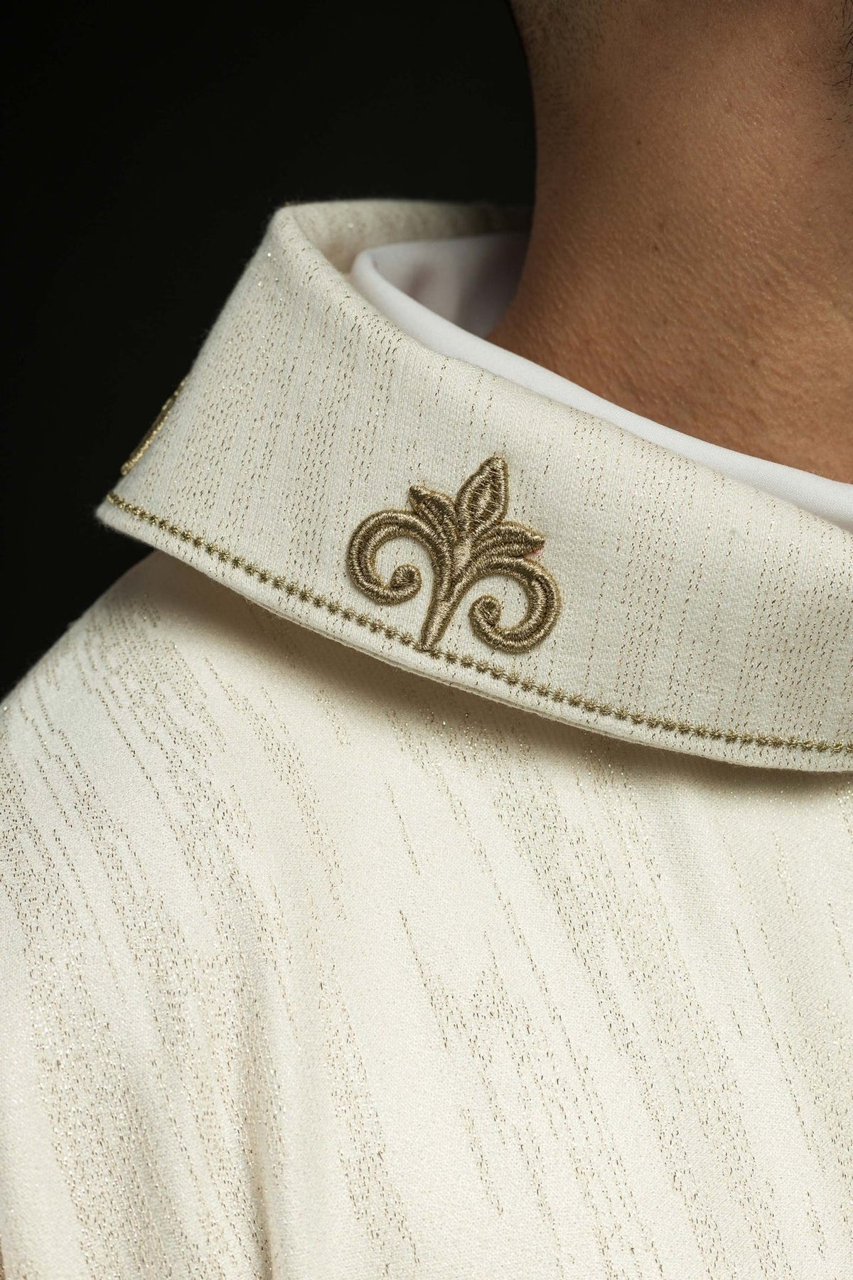 Ecru chasuble detail showing embroidered gold cross and wide sleeves