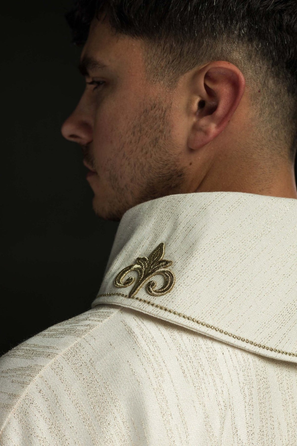 Ecru chasuble close-up showing decorative fabric and gold embroidered cross