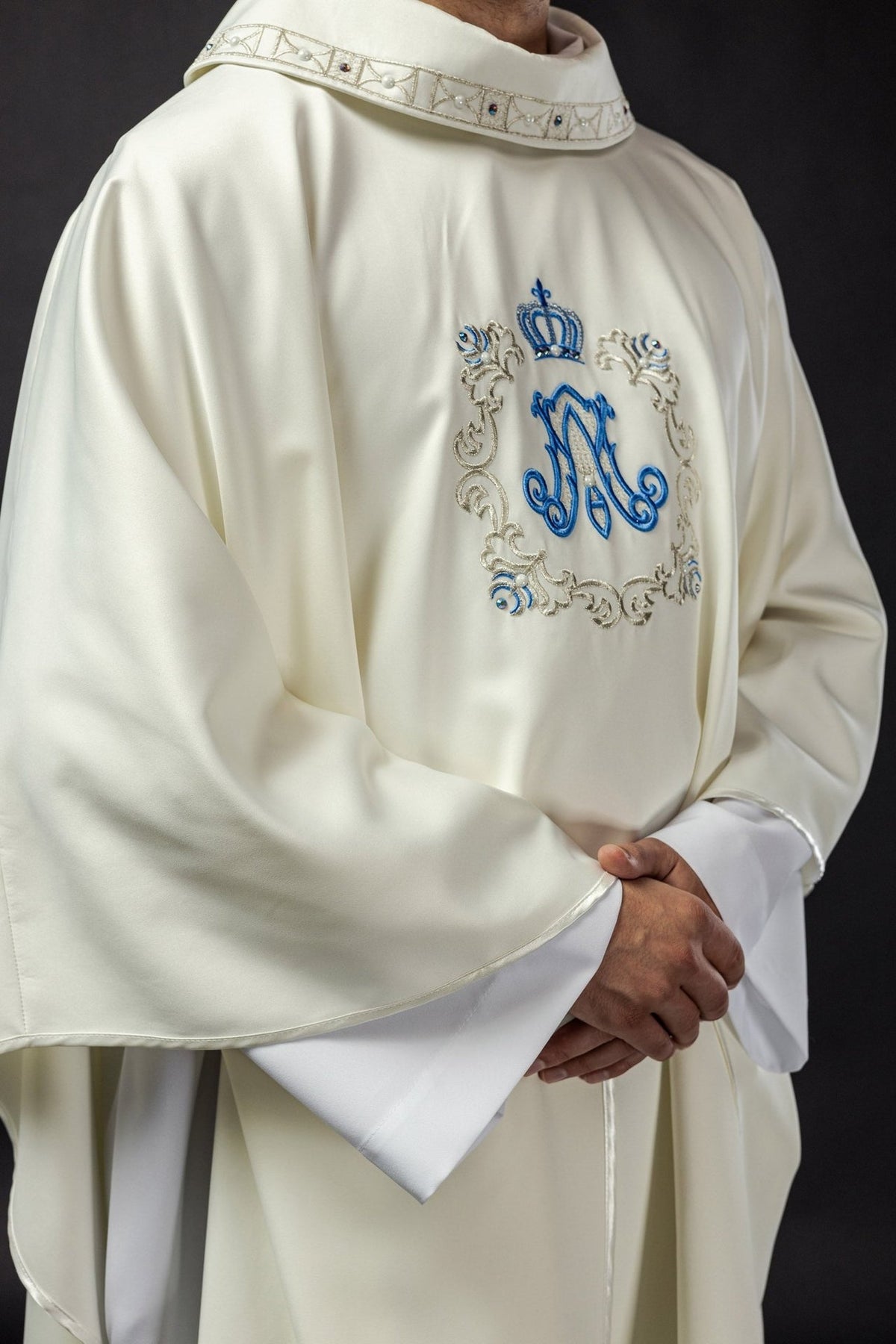 Marian chasuble side view showing ivory fabric, embroidered front and wide sleeves