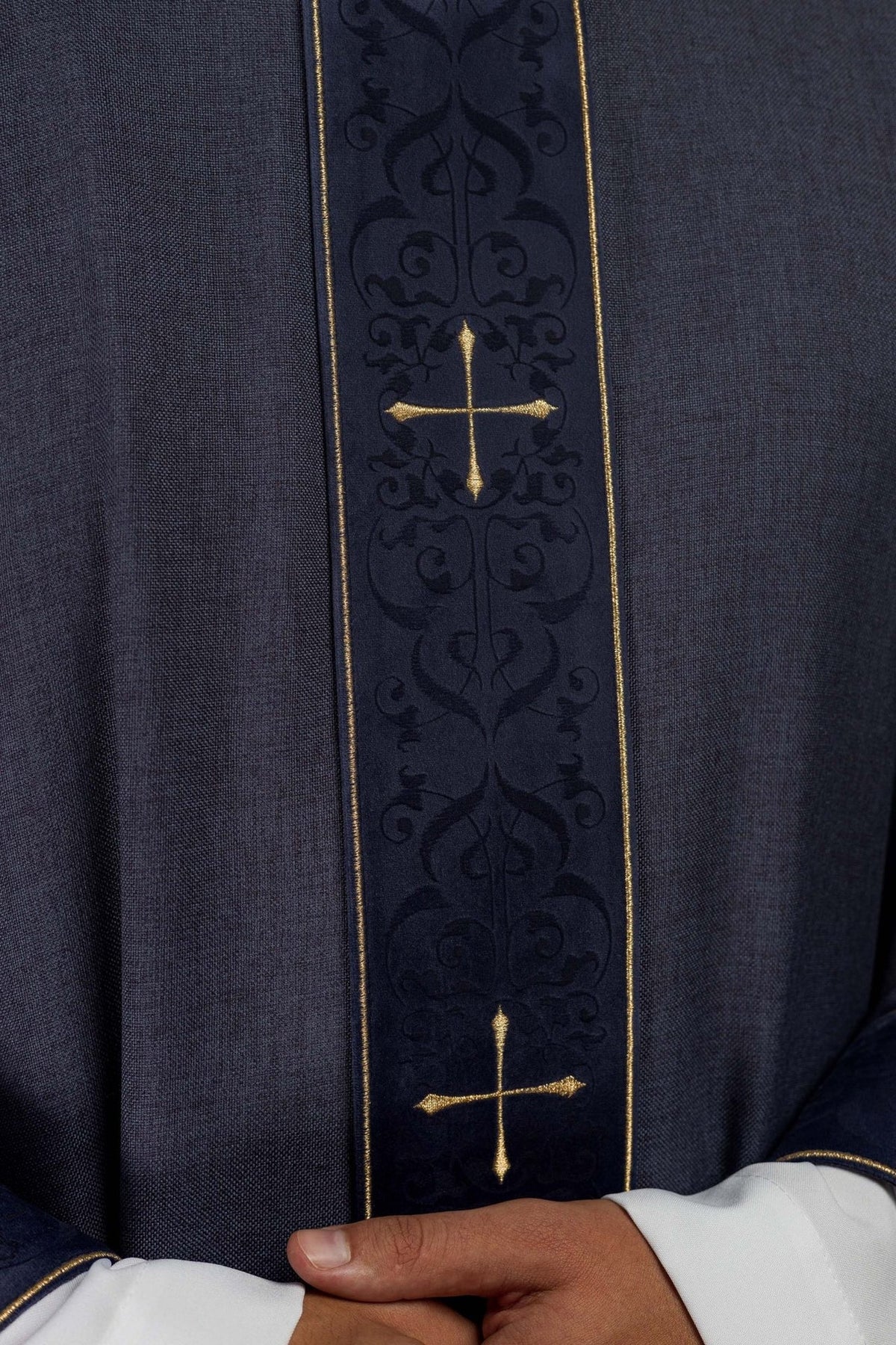 Purple chasuble close-up of embroidered orphrey with gold cross and dark floral motifs