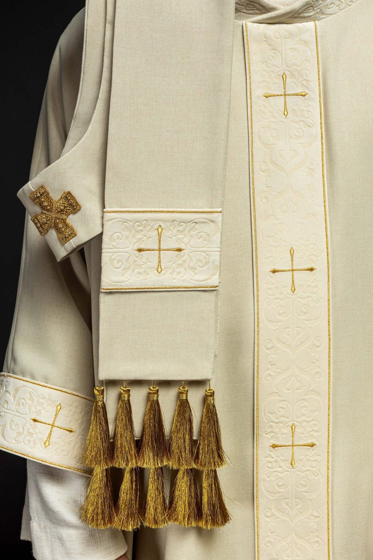 Ecru chasuble front detail with orphrey, sleeve embroidery, gold cross and tassels