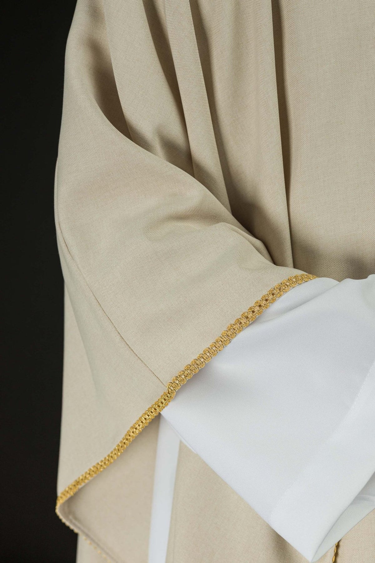 Ecru chasuble close-up showing gold trim on sleeve edge