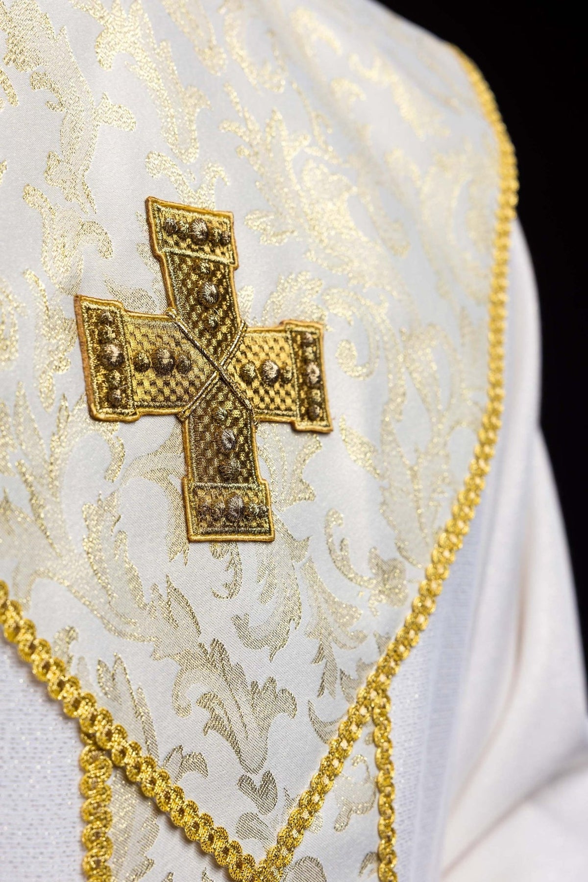 Ecru chasuble close-up showing gold cross on jacquard orphrey