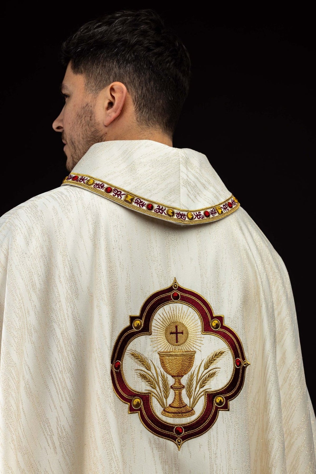 Chasuble close-up showing embroidered communion chalice, altar bread and wheat
