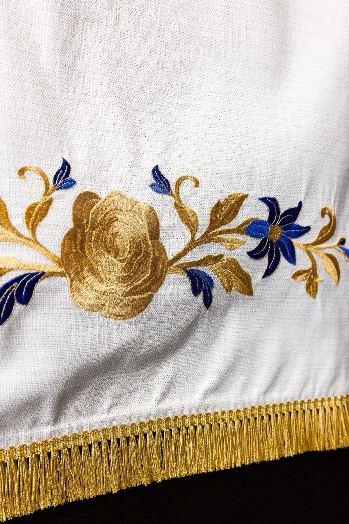 Church lectern cover detail with embroidered gold rose, blue flowers and gold fringe