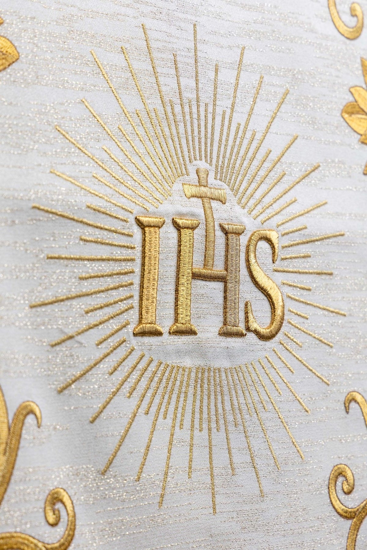 Ecru church lectern cover close-up with embroidered gold IHS monogram and radiating lines
