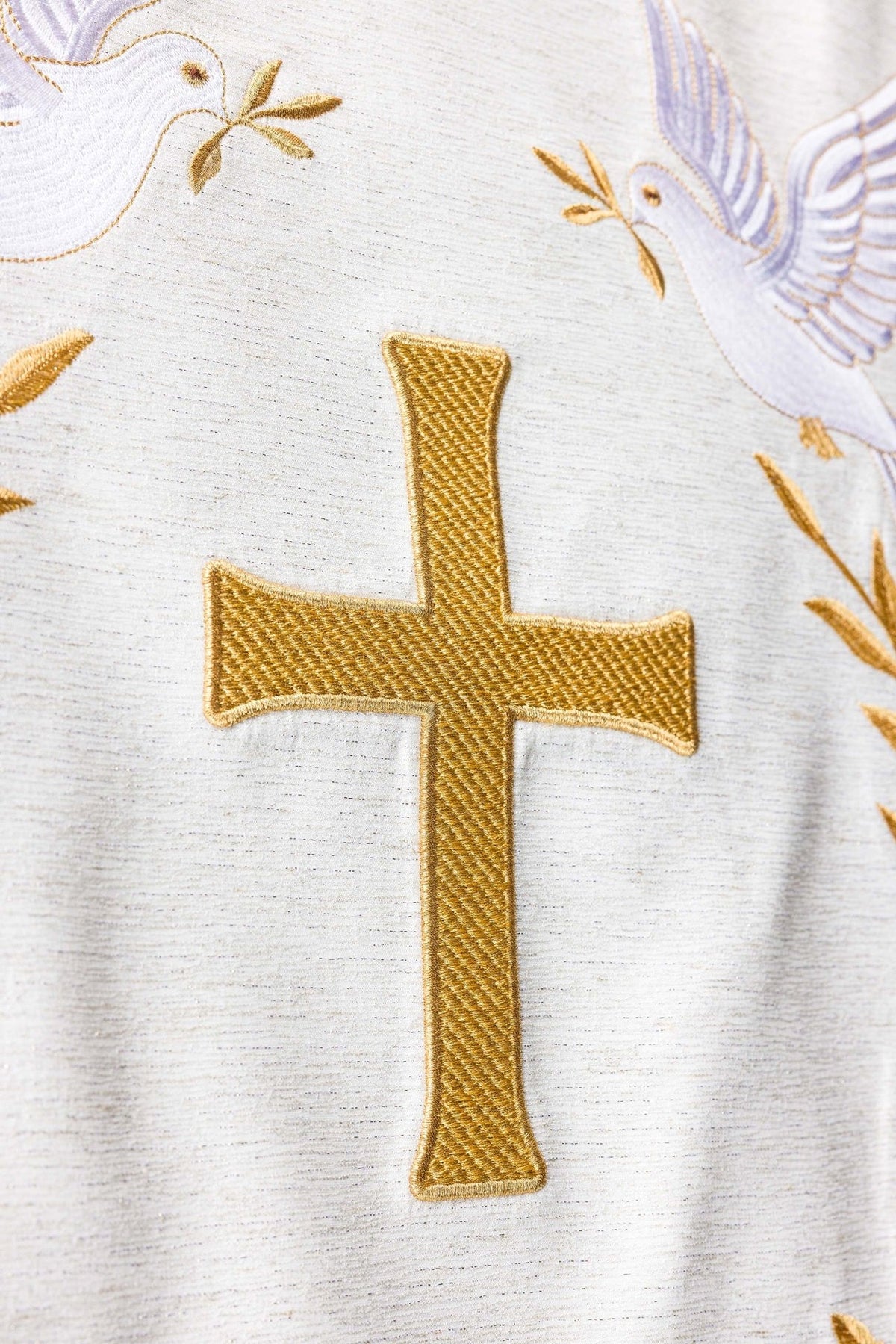 Church lectern cover close-up of the gold cross embroidery between white doves