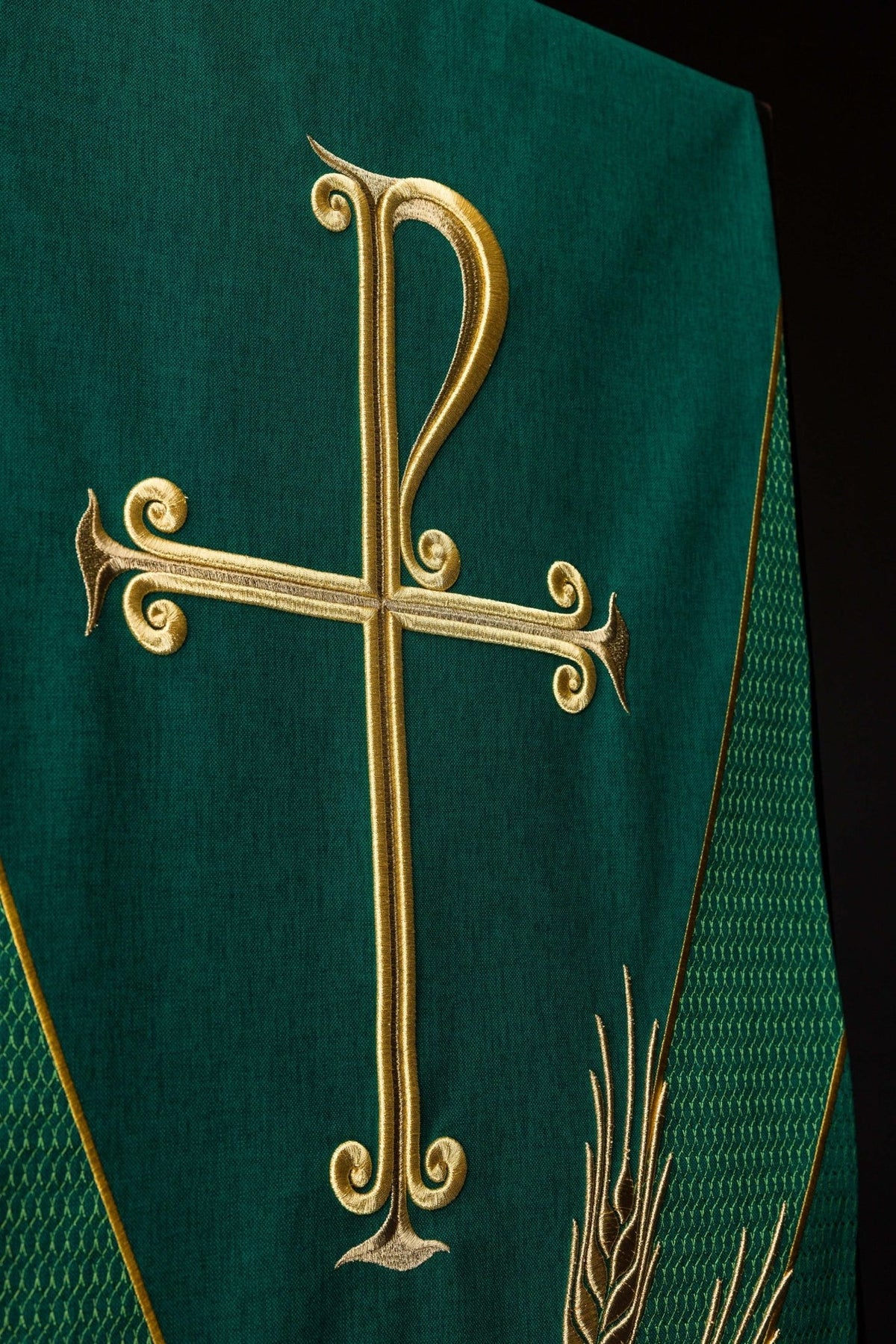 Green church lectern cover close-up showing gold PAX cross and wheat embroidery