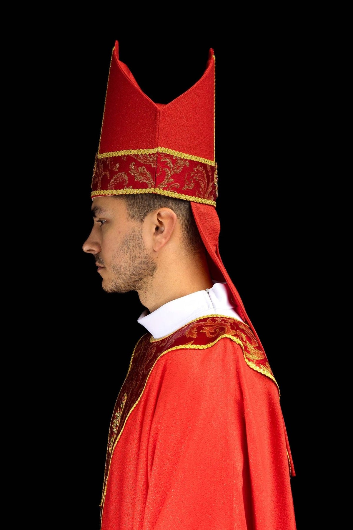 Red miter side close-up with embroidered gold cross, jacquard fabric and trim