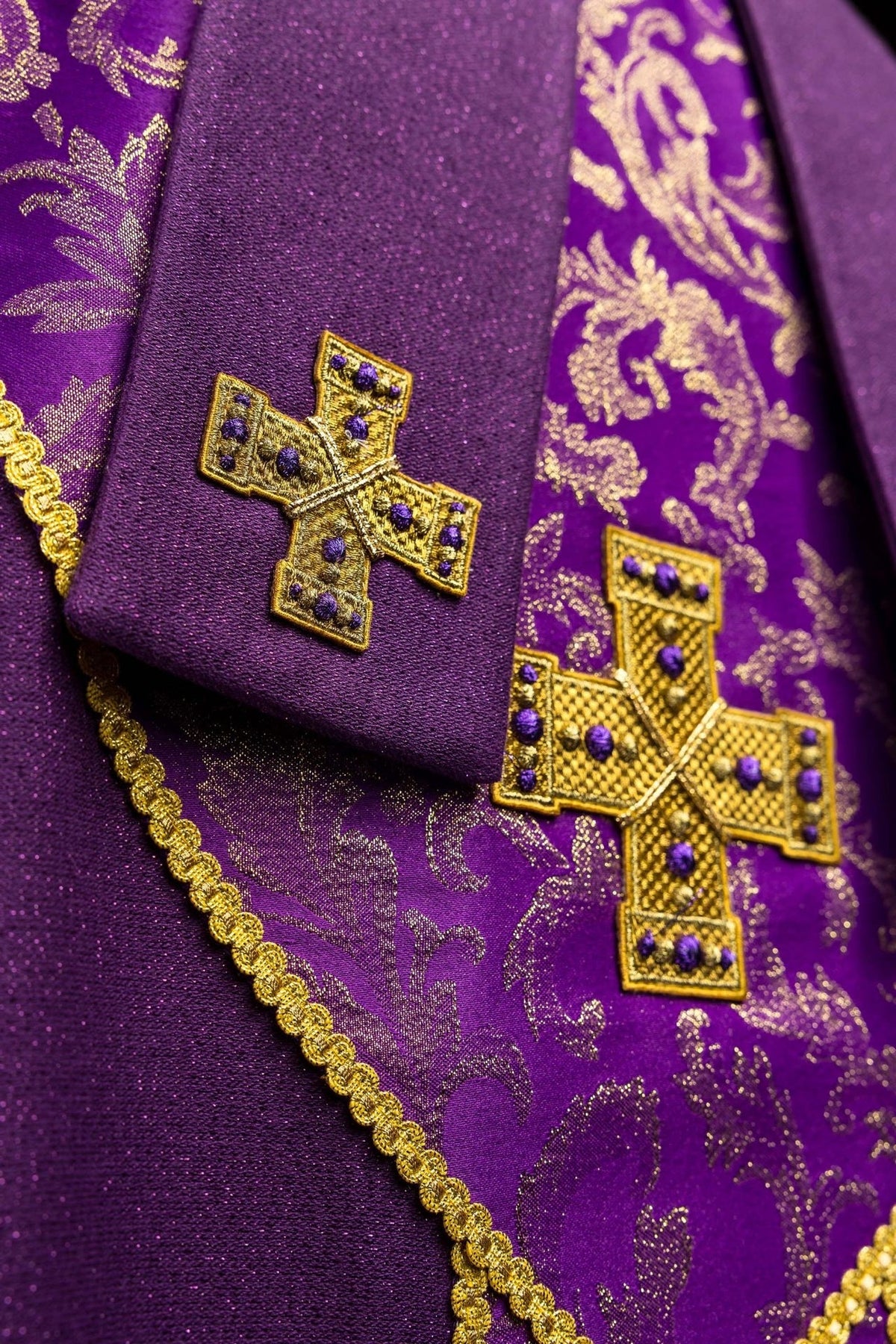 Purple miter close-up showing embroidered cross on jacquard fabric