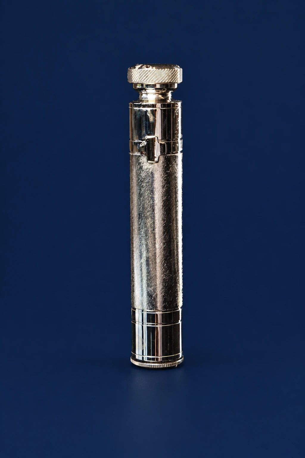 Metal aspergillum shown upright, with cylindrical handle and knurled cap for holy water sprinkling
