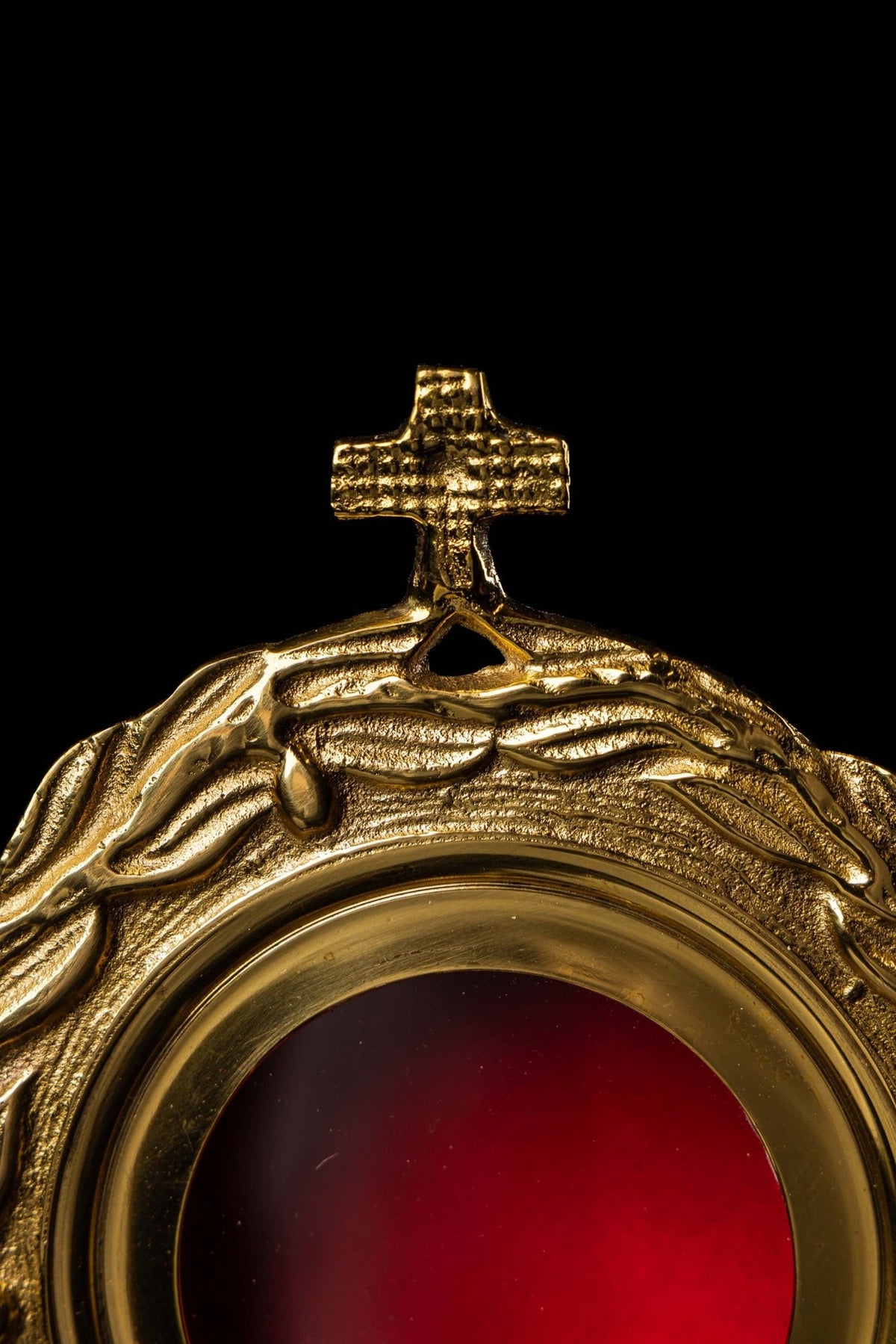Brass reliquary upper detail showing cross and wreath motif