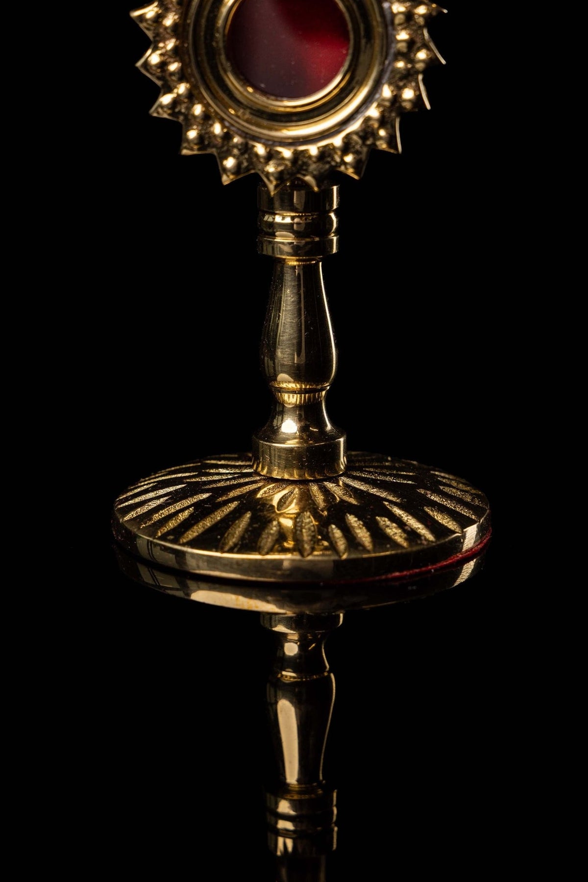 Brass reliquary close-up of the stem and sunburst-patterned base